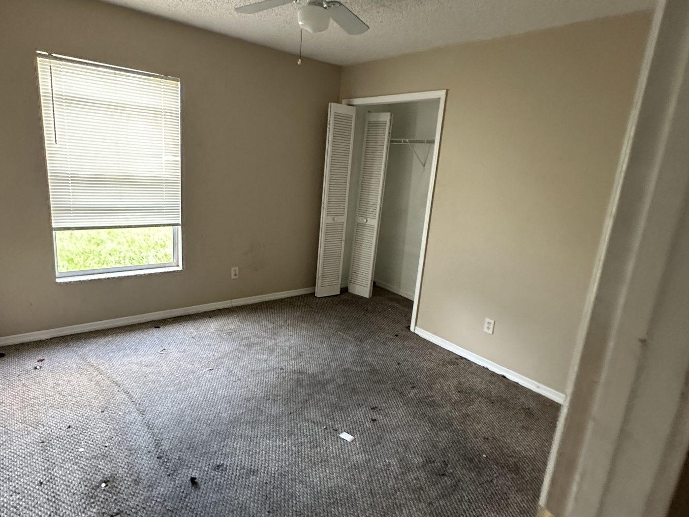 Empty bedroom with the carpet stained by moisture rising through the concrete slab