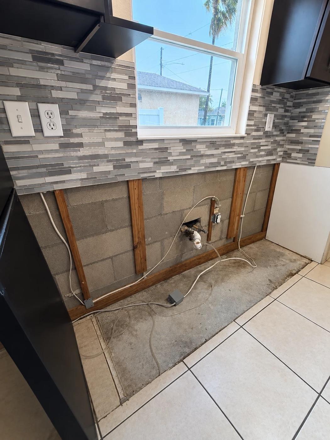 The same Winter Park kitchen with the base cabinet and lower drywall removed, the block wall exposed, dried and treated, ready for rebuild