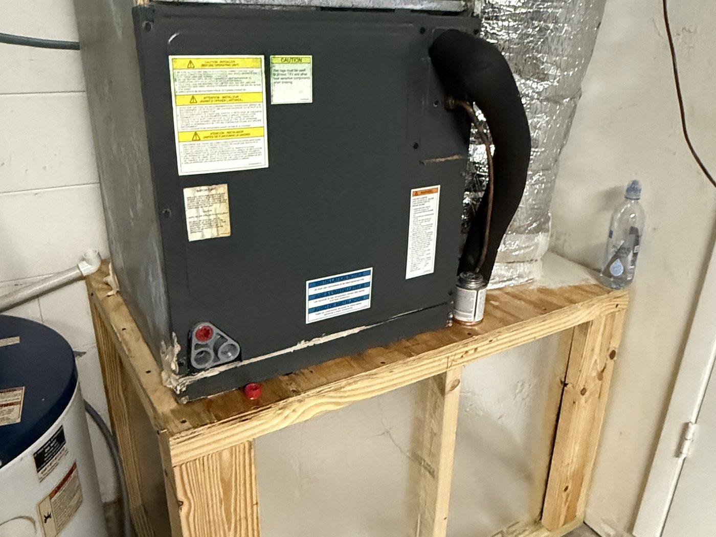 The new air handler installed on a pressure-treated platform, with new insulated flex duct
